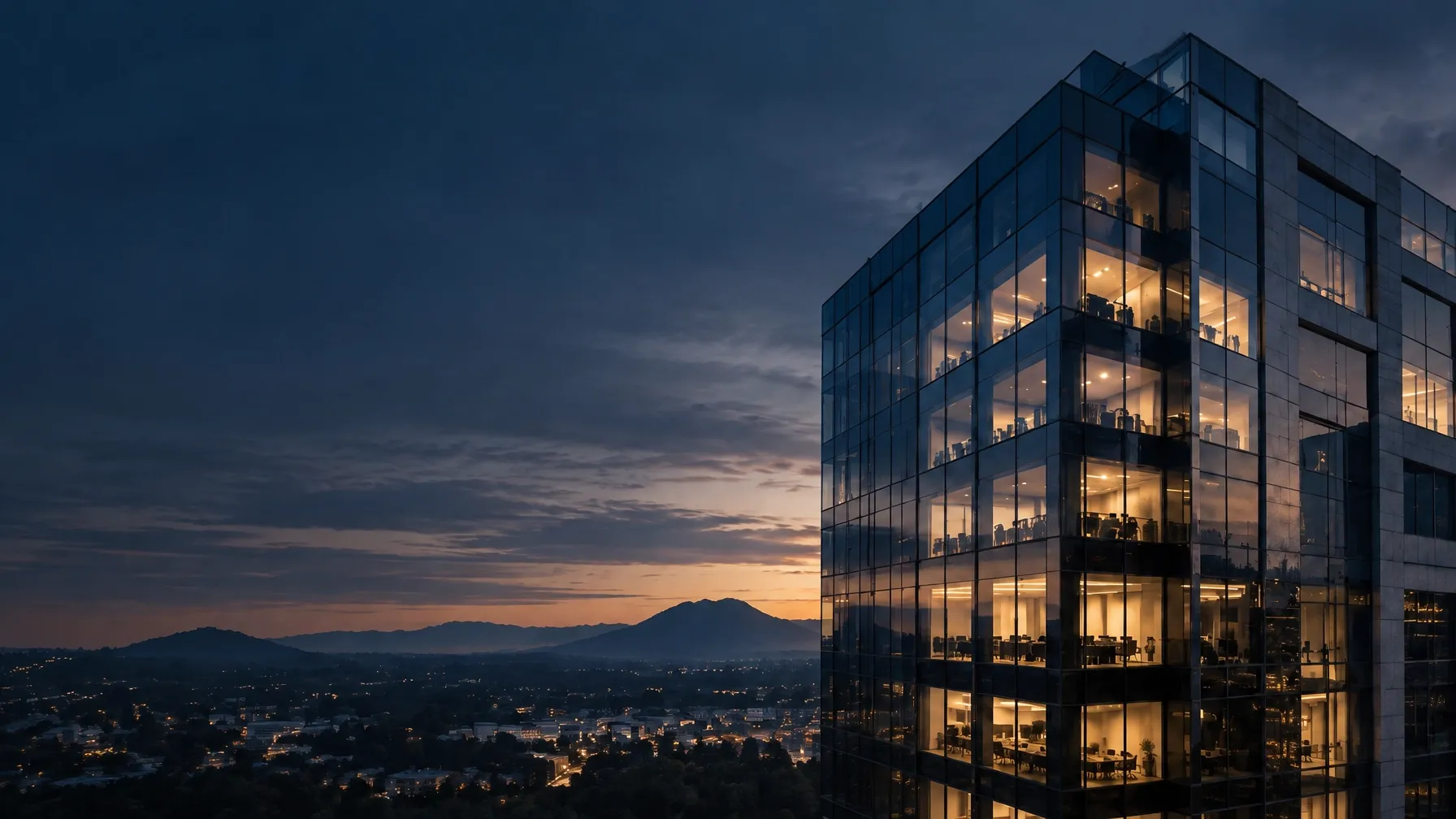 Modern glass and stone office tower at dusk